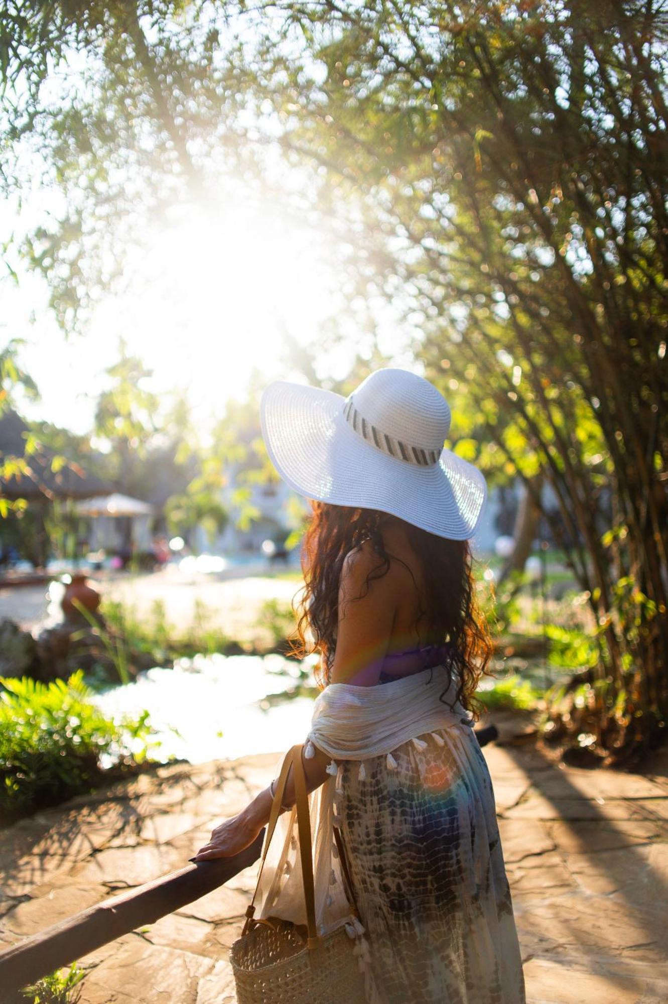 Diamonds Leisure Beach & Golf Resort Diani Beach Eksteriør bilde A woman wearing a sun hat
